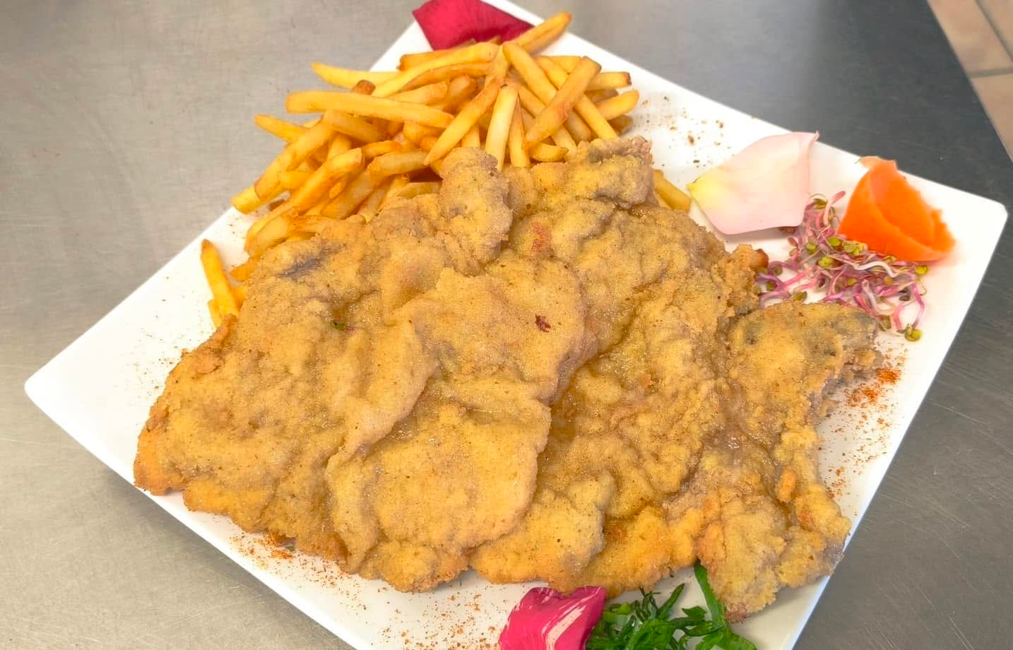 Kotlet schabowy podany z frytkami i surówką
